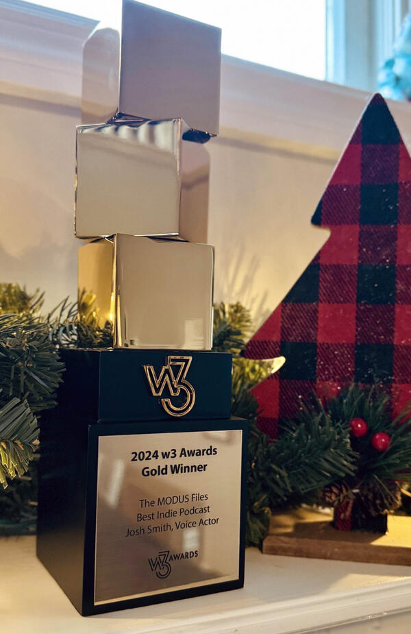 Josh Smith's W3 Podcast Gold Award trophy recognizing excellence in voice acting for podcasts.
